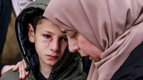 طفل فلسطيني مصاب بجروح في وجهه، يتلقى الدعم من امرأة ترتدي الحجاب، في سياق حادثة إطلاق نار من القوات الإسرائيلية في طمّون.