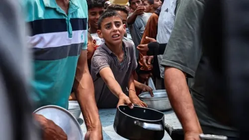 طفل فلسطيني يظهر في حالة من القلق أثناء محاولته الحصول على الطعام وسط حشد من الناس في غزة، في ظل أزمة إنسانية متفاقمة.