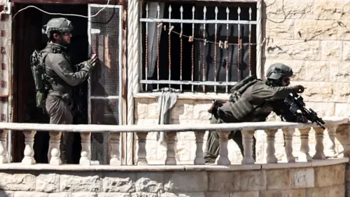 جنود إسرائيليون يقتربون من منزل فلسطيني في جنين، مع وجود أسلحة، في سياق أوامر الإخلاء المتزايدة في الضفة الغربية.