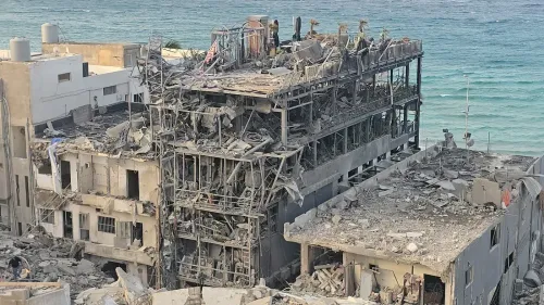 تظهر الصورة مبنى مدمر في جنوب لبنان، حيث تتناثر الأنقاض على الساحل، مما يعكس آثار الهدم الممنهج خلال النزاع.