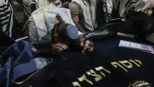 شخص يضع جبهته على سجادة صلاة في موقع قبر يوسف، محاطًا بأشخاص آخرين يرتدون ملابس دينية، خلال صلاة تلمودية تحت حماية عسكرية.