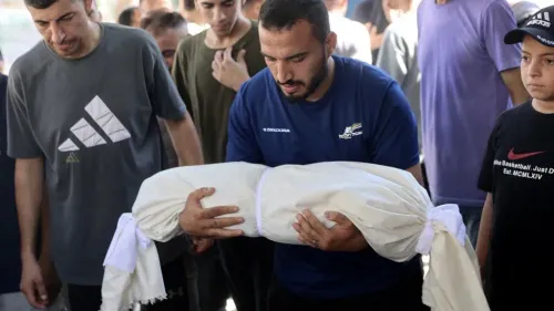 رجل يحمل جثمان ملفوف بقطعة قماش بيضاء وسط مجموعة من الرجال الشباب في جنازة فلسطينية، تعبير عن الخسائر البشرية في غزة رغم اتفاق وقف إطلاق النار مع إسرائيل.