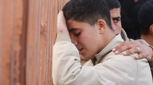 شاب فلسطيني يبكي بجوار شخص آخر، معبرًا عن الحزن بعد الغارات الإسرائيلية على غزة، التي أسفرت عن مقتل العديد من المدنيين.