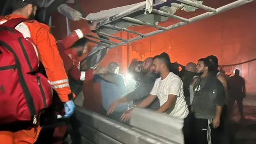 فرق الإنقاذ تعمل على إزالة الأنقاض في مخيم عين الحلوة بعد غارة جوية إسرائيلية، مع وجود مدنيين مصابين في المنطقة المظلمة.