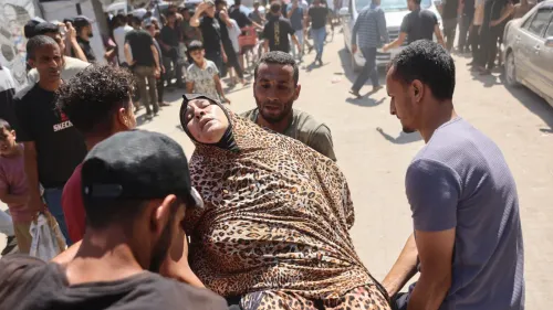 رجال يحملون امرأة مصابة وسط حشد في غزة بعد غارة جوية إسرائيلية استهدفت مقر شرطة محافظات غزة، ما أسفر عن قتلى وجرحى.