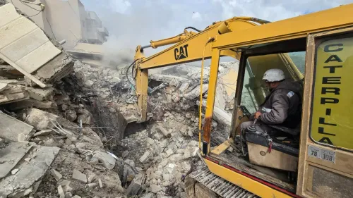 معدة ثقيلة تعمل على إزالة الأنقاض في منطقة مدمرة، تعكس آثار التدمير الواسع في القرى اللبنانية المقابلة للحدود مع إسرائيل.