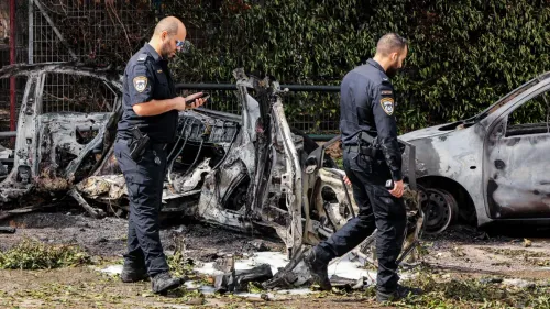 رجال شرطة إسرائيليون يتفقدون حطام سيارات محترقة في موقع حادث، وسط توترات متزايدة في المنطقة بسبب الصراع المستمر مع إيران.