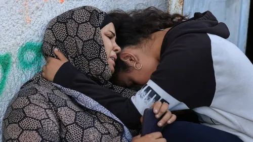 امرأتان تحتضنان بعضهما في لحظة حزن، تعكسان مشاعر الألم والمعاناة في غزة وسط الأوضاع المتوترة.