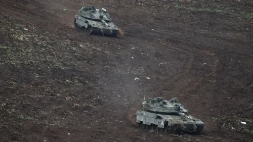 دبابات إسرائيلية تتحرك في منطقة وعرة، تعكس التصعيد العسكري في لبنان وتوجهات الحكومة الإسرائيلية للسيطرة على الحدود.