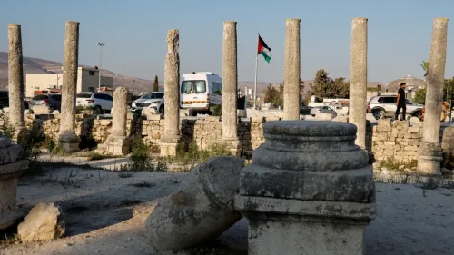 آثار تاريخية في سبسطية، مع أعمدة قديمة، علم فلسطين يرفرف في الخلفية، تشير إلى محاولات إسرائيل للاستيلاء على الأراضي.