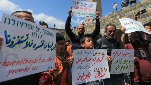احتجاجات في الشوارع مع متظاهرين يحملون لافتات تعبر عن الغضب تجاه الاعتداءات الإسرائيلية على الأراضي السورية، تعكس مشاعر المقاومة.