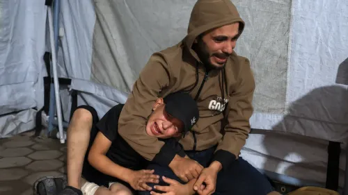 رجل يبكي ويحتضن طفلاً في خيمة نازحين بغزة، بعد الغارات الجوية الإسرائيلية التي أسفرت عن مقتل العديد من المدنيين.