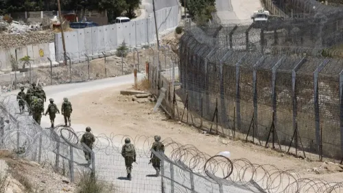 جنود يسيرون بالقرب من السياج الحدودي بين سوريا وإسرائيل، في منطقة تشهد توترات أمنية ومفاوضات للاتفاق الأمني.