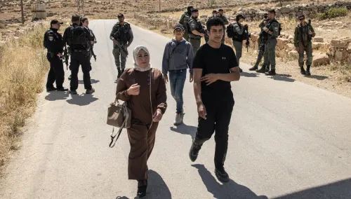 احتجاز أفراد من عائلة مخامرة الفلسطينية في مسافر يطا، بينما يتواجد الجنود الإسرائيليون في الخلفية، بعد اشتباكات مع مستوطنين.