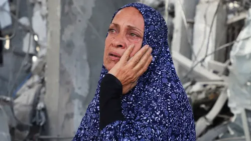 امرأة ترتدي حجابًا مزخرفًا، تعبر عن الحزن والقلق في وسط أنقاض، تعكس تأثير القيود الإسرائيلية على المساعدات الإنسانية في غزة.