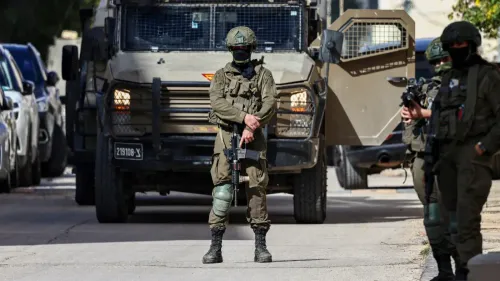 جنود إسرائيليون في حالة تأهب خلال عملية عسكرية في شمال الضفة الغربية، مع مركبات عسكرية في الخلفية، وسط تصاعد العنف.