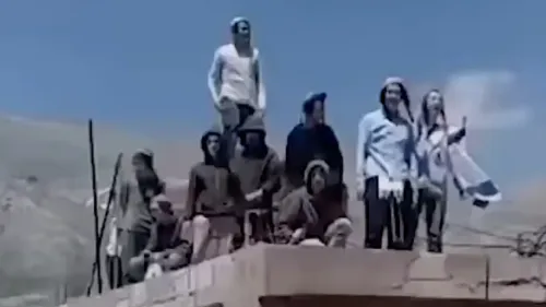 مستوطنون إسرائيليون يقفون على سطح مبنى في قرية حضر السورية، رافعين الأعلام، خلال اقتحامهم للأراضي السورية.