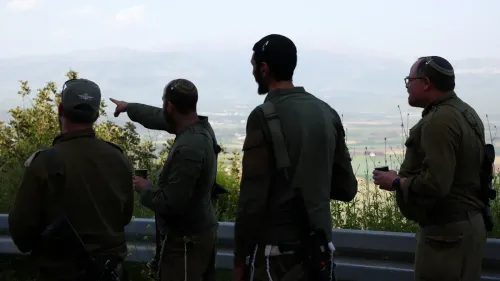 جنود إسرائيليون يتجمعون في منطقة مرتفعة، يتبادلون الحديث والنظر إلى الأفق، وسط مشهد طبيعي في جنوب لبنان، في سياق عمليات نهب ممنهجة.