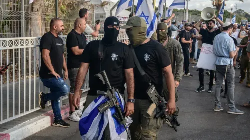 محتجون يرتدون أقنعة سوداء ويحملون أسلحة، يتظاهرون في شارع مع أعلام إسرائيلية، وسط أجواء متوترة تعكس الانتهاكات بحق الفلسطينيين.