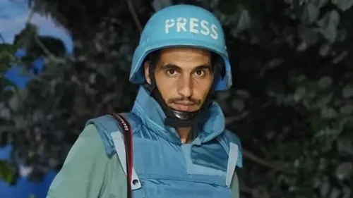 صحفي فلسطيني يرتدي خوذة زرقاء مكتوب عليها "PRESS"، يظهر في بيئة طبيعية، يعكس التحديات التي واجهها خلال تغطيته للصراع.