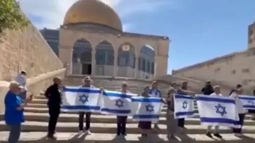 مستوطِنون إسرائيليون يحملون الأعلام الإسرائيلية في المسجد الأقصى، مع قبة الصخرة في الخلفية، خلال اقتحامٍ مثير للجدل.