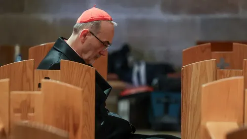 كاردينال يجلس في كنيسة فارغة، مع التركيز على تعبيره الجاد، في سياق منع الوصول إلى الأماكن المقدسة في القدس.