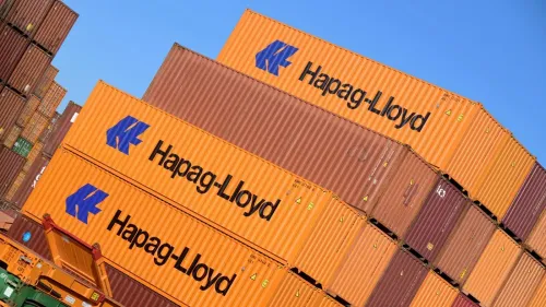 حاويات شحن ملونة تحمل شعار شركة Hapag-Lloyd، تشير إلى استحواذها على شركة ZIM الإسرائيلية بقيمة 4.2 مليار دولار.