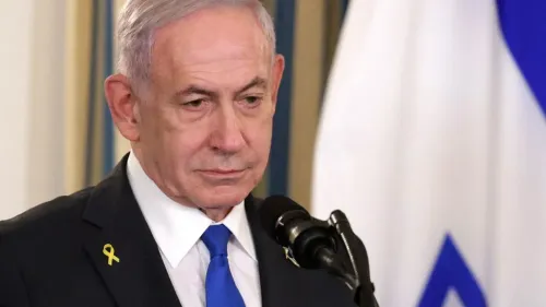 رئيس الوزراء الإسرائيلي بنيامين نتنياهو يتحدث بجدية، مع وجود علم إسرائيل خلفه، في سياق ردود الفعل على الهجوم على شاطئ بوندي.