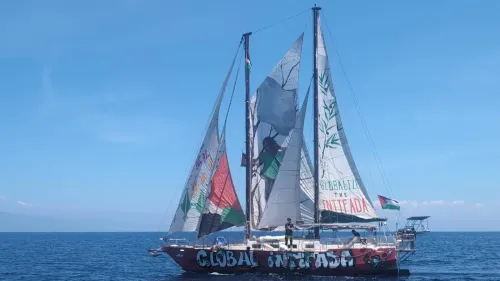 سفينة تحمل شعار "Global Intifada" تبحر في البحر، مع أعلام فلسطينية، خلال حملة احتجاج ضد الإمداد العسكري في ميناء جيويا تاورو الإيطالي.