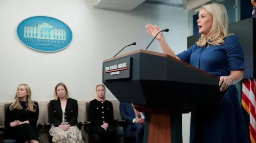 السكرتيرة الصحفية للبيت الأبيض، كارولين ليفيت، تتحدث خلال مؤتمر صحفي، بينما يجلس عدد من الموظفين خلفها.