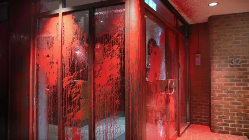 واجهة مبنى مغطاة بالطلاء الأحمر، تشير إلى احتجاجات ضد الشركات المملوكة لليهود، في سياق انتقادات لمنظمة العمل الفلسطيني.