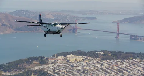 طائرة Cessna Caravan ذاتية القيادة تطير فوق سان فرانسيسكو مع جسر غولدن غيت في الخلفية، ضمن رحلة تجريبية لشركة Joby Aviation.