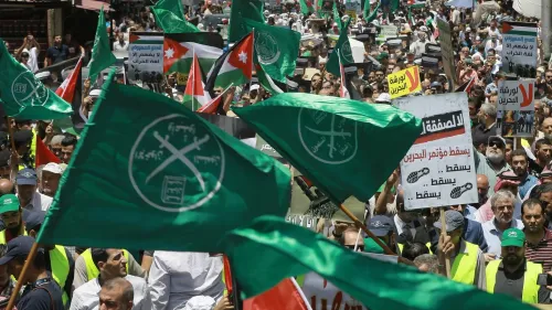 مظاهرة حاشدة في الأردن، حيث يحمل المتظاهرون أعلام جماعة الإخوان المسلمين ولافتات تعبر عن مطالب سياسية، وسط أجواء مشحونة.