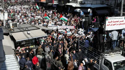 تظاهر حشد كبير في الأردن ضد تهجير الفلسطينيين، حاملين الأعلام الفلسطينية واللافتات، في سياق التوترات الإقليمية الحالية.