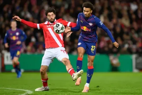 لاعبو كرة القدم من فريق لايبزيغ وفريق كوتبوس يتنافسون على الكرة في مباراة كأس ألمانيا، وسط أجواء هادئة بعد حادث مؤسف.