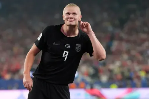 هالاند يحتفل بعد تسجيله هدفين في كأس العالم، مرتديًا قميص النرويج الأسود، مع تعبير عن الثقة في ملعب مليء بالجماهير.