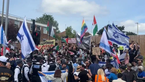 تجمع حشود من المتظاهرين في لندن يحملون أعلامًا إسرائيلية وفلسطينية، مع وجود شرطة تراقب الوضع.