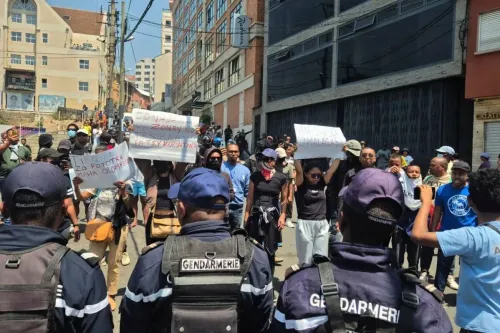 محتجون في مدغشقر يتظاهرون ضد انقطاع المياه والكهرباء، حاملين لافتات تدعو إلى تحسين الخدمات الأساسية، بينما تراقبهم الشرطة.