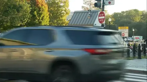 سيارة تسير بسرعة بالقرب من حاجز أمني في البيت الأبيض، مع وجود لافتات تحذيرية تشير إلى عدم الدخول.