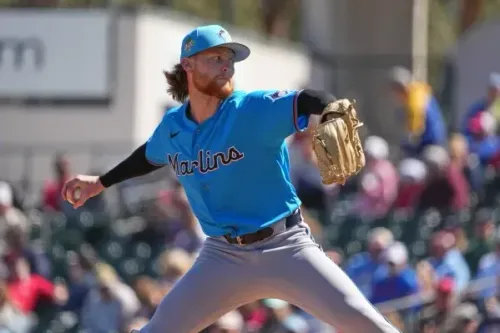 لاعب البيسبول براكستون جاريت في زي فريق مارلينز، أثناء رمي الكرة في مباراة، مع خلفية جماهيرية واضحة.