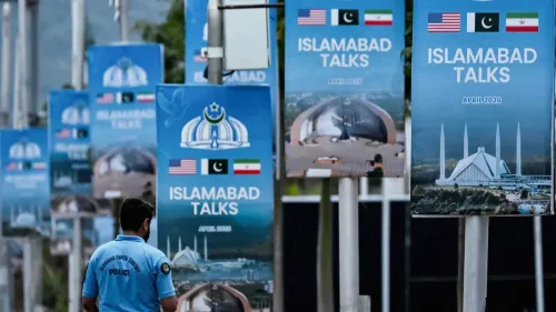 لافتات تشير إلى محادثات إسلام آباد بين الولايات المتحدة وإيران وباكستان، مع وجود شرطي في المقدمة.