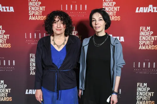 المخرجة جوليا لوكتيف مع المخرجة لورا بويتراس في حفل جوائز Film Independent Spirit، مرتديتان أزياء رسمية أمام خلفية شعار الجوائز.