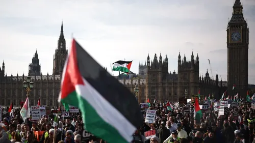 مظاهرة حاشدة في لندن لدعم فلسطين، حيث يرفع المحتجون الأعلام الفلسطينية واللافتات، مع معالم البرلمان البريطاني في الخلفية.
