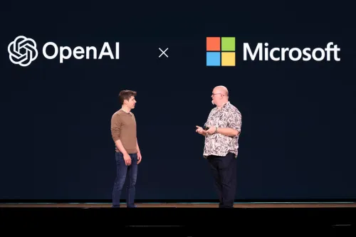 شخصان يتحدثان أمام خلفية شعار OpenAI وشعار Microsoft، تعبير عن الشراكة والتنافس في مجال الذكاء الاصطناعي والإيرادات المشتركة.