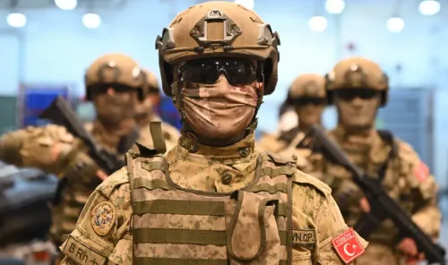 جنود أتراك يرتدون زيًا عسكريًا كاملًا، مع أسلحة ومعدات، في قاعدة عسكرية، مما يعكس استعداد تركيا لتعزيز قوة الناتو في المنطقة.