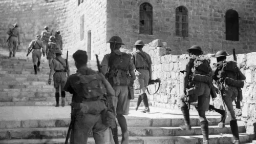جنود بريطانيون يتسلقون الدرج في فلسطين خلال فترة الانتداب، مما يعكس التوترات التاريخية والصراعات في تلك الحقبة.