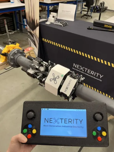 روبوت Nexterity المحمول لفك وربط براغي وصلات الفلنجة في الأنابيب الصناعية مع جهاز تحكم يدوي، لتسهيل أعمال فن الأنابيب وتقليل الإرهاق.