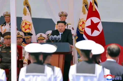 كيم جونغ أون يلقي خطابًا خلال تدشين المدمّرة "Choe Hyon" في ميناء نامبو، محاطًا بالضباط والرايات البحرية، مؤكدًا على تعزيز القدرات النووية البحرية لكوريا الشمالية.