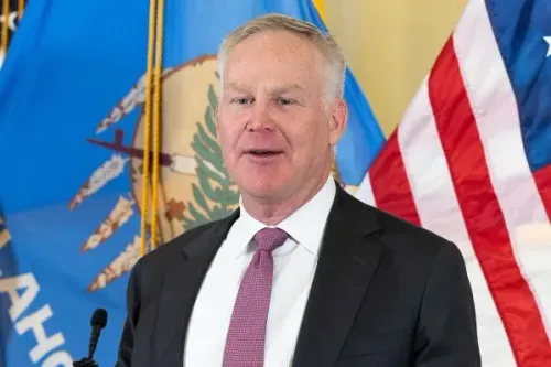 آلان أرمسترونغ، المدير التنفيذي للطاقة، يتحدث في مؤتمر صحفي بعد تعيينه في مجلس الشيوخ الأمريكي، مع العلم الوطني لأوكلاهوما في الخلفية.