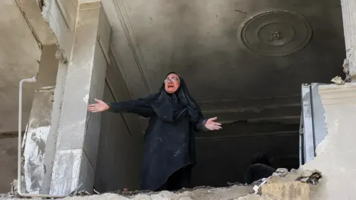 امرأة ترتدي الحجاب وتقف في مكان مدمر، تعبر عن مشاعر الألم والاحتجاج بعد الهجمات العسكرية، مما يعكس تأثير الحرب على المدنيين.